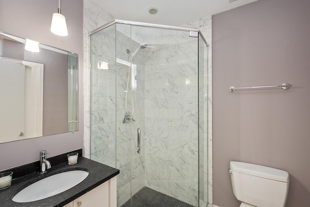 bathroom with vanity, a shower with shower door, and toilet