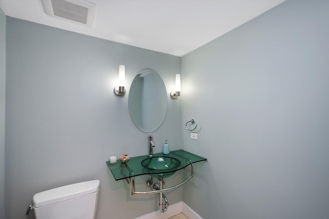 bathroom featuring toilet, tile patterned flooring, and sink