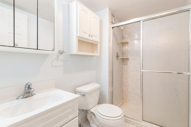 bathroom featuring vanity, toilet, and a shower with door