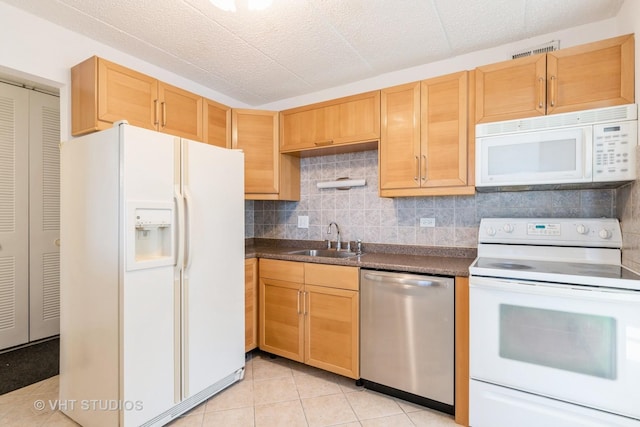 kitchen featuring sink, white appliances, light tile patterned floors, backsplash, and light brown cabinets