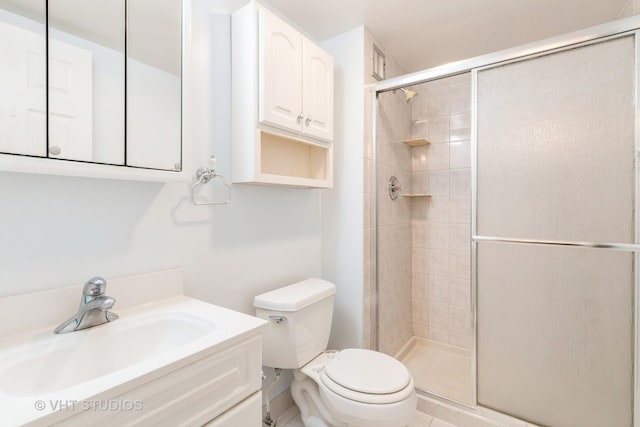 bathroom with vanity, a shower with shower door, and toilet