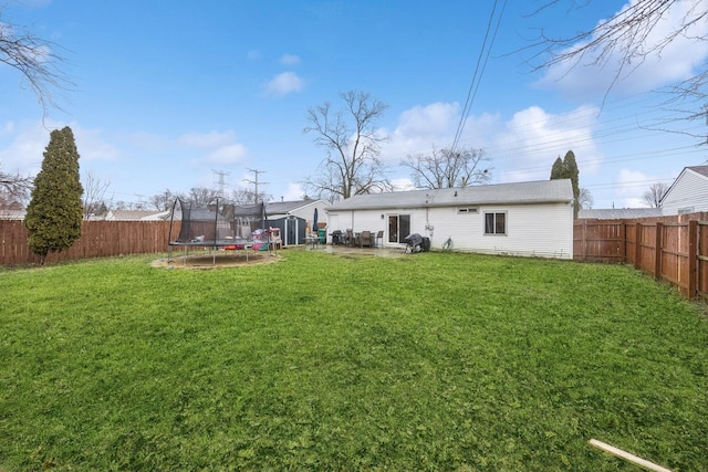 back of property with a patio area, a lawn, and a trampoline