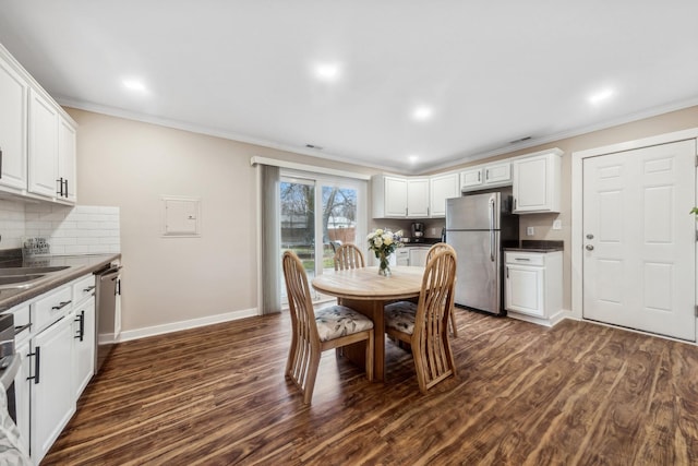 dining area featuring sink, dark hardwood / wood-style floors, and ornamental molding