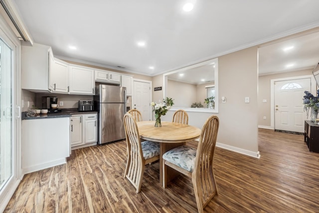 dining area with wood-type flooring and crown molding