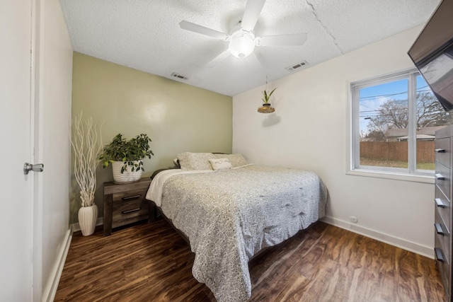 bedroom featuring dark wood-type flooring, ceiling fan, and a textured ceiling