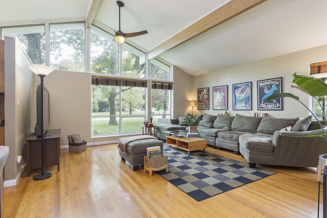 living room featuring ceiling fan, light hardwood / wood-style flooring, vaulted ceiling with beams, and a healthy amount of sunlight