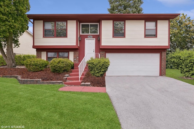 bi-level home featuring a garage and a front yard