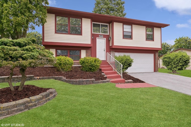 bi-level home featuring a garage and a front lawn