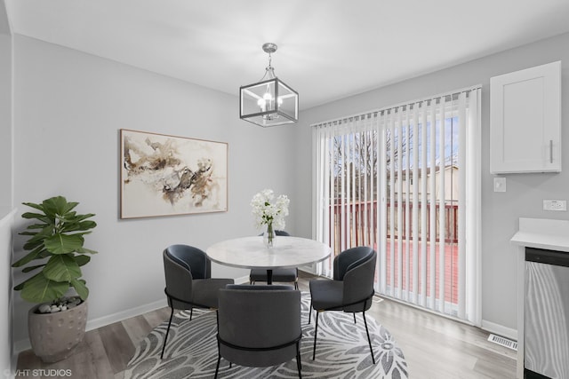 dining space with an inviting chandelier and light hardwood / wood-style floors