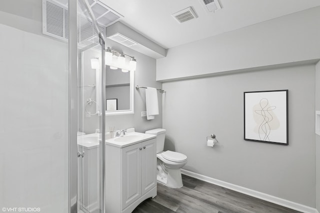 bathroom featuring wood-type flooring, toilet, and vanity