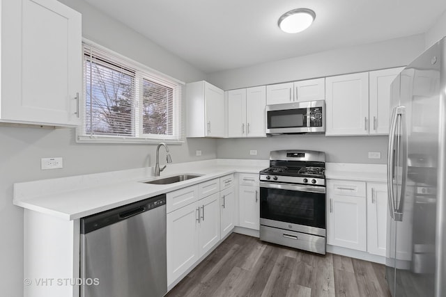 kitchen featuring stainless steel appliances, sink, and white cabinets