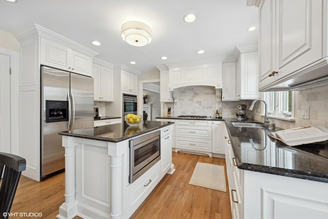 kitchen featuring a kitchen island, tasteful backsplash, appliances with stainless steel finishes, and white cabinets