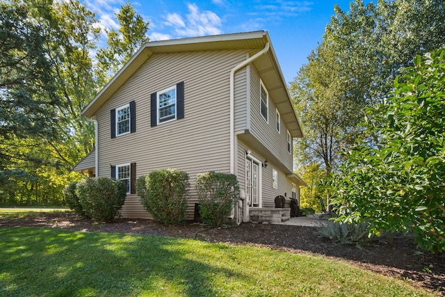 view of side of property with a patio area and a lawn