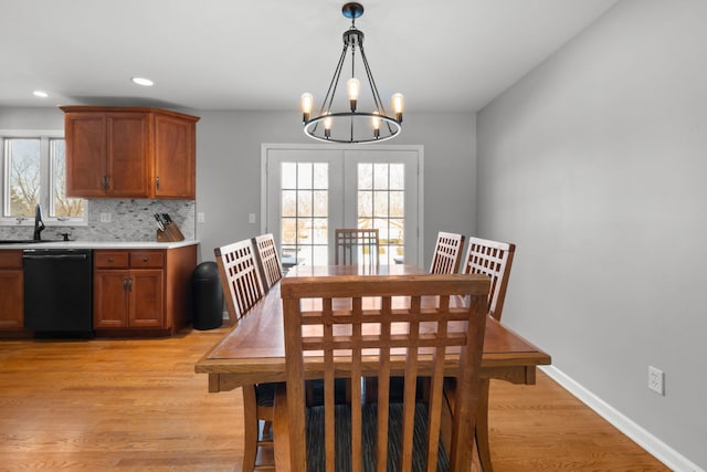 dining space with plenty of natural light, sink, a chandelier, and light hardwood / wood-style floors