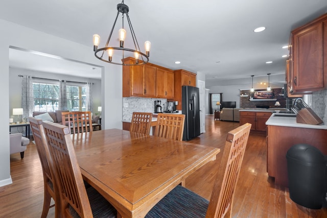 dining space featuring sink, dark hardwood / wood-style flooring, and a chandelier