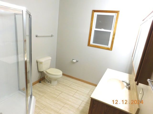 bathroom featuring an enclosed shower, vanity, and toilet