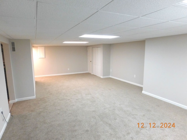 basement with a drop ceiling and carpet flooring