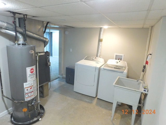 laundry area featuring water heater, washer and dryer, and sink