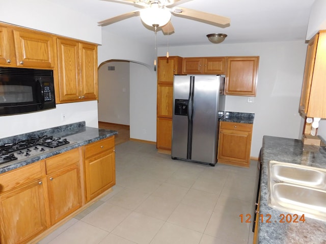 kitchen with light tile patterned flooring, sink, gas cooktop, ceiling fan, and stainless steel refrigerator with ice dispenser