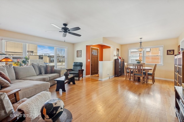 living room featuring ceiling fan, light hardwood / wood-style floors, and a wealth of natural light