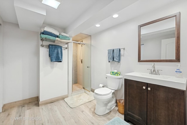 bathroom with vanity, a shower with shower door, hardwood / wood-style floors, and toilet