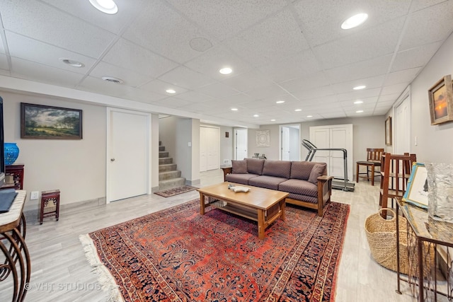 living room featuring a paneled ceiling and light wood-type flooring