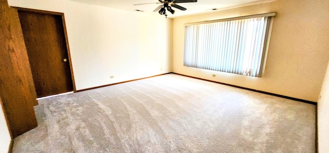 carpeted spare room with ceiling fan and plenty of natural light