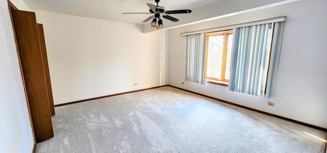 spare room with ceiling fan and light colored carpet