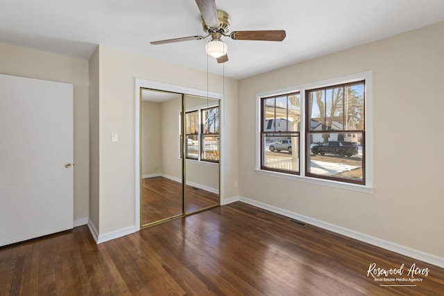 unfurnished bedroom featuring a closet, dark hardwood / wood-style flooring, and ceiling fan