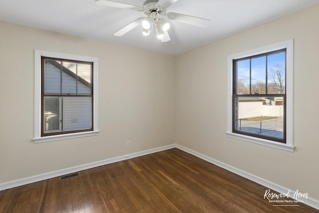 spare room with ceiling fan and dark hardwood / wood-style floors