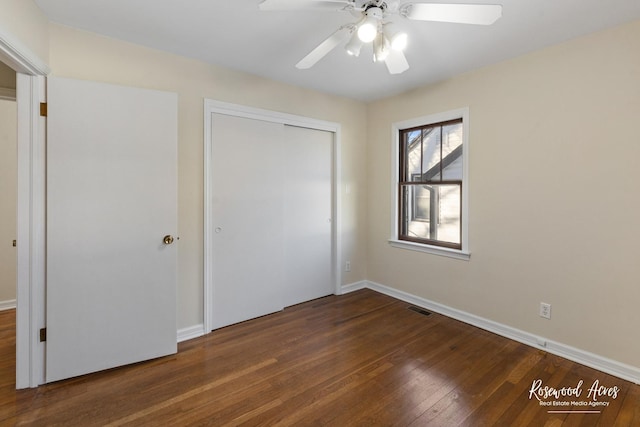 unfurnished bedroom featuring ceiling fan, a closet, and dark hardwood / wood-style flooring