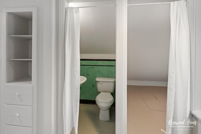 bathroom featuring toilet, tile walls, tile patterned floors, and built in shelves