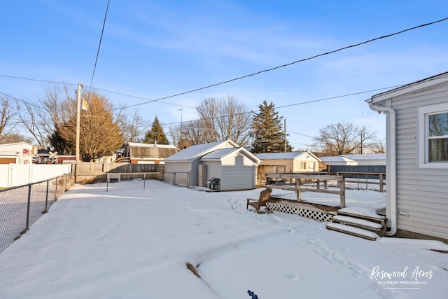 yard layered in snow featuring a storage shed