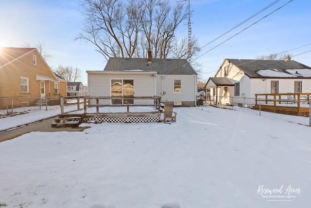 snow covered rear of property featuring a deck