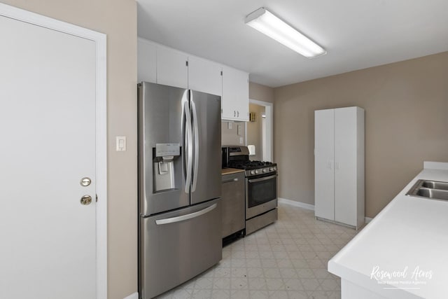 kitchen with stainless steel appliances, white cabinetry, and sink