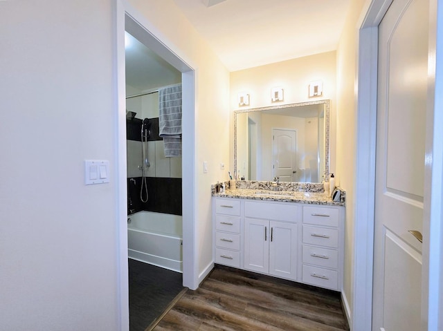 bathroom with wood-type flooring, shower / washtub combination, and vanity