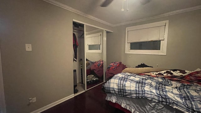 bedroom with a ceiling fan, baseboards, ornamental molding, and a closet