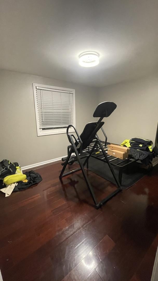 workout room featuring baseboards and wood finished floors