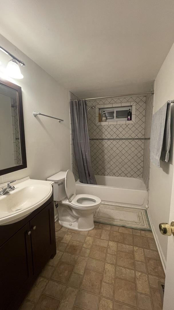 bathroom featuring toilet, shower / tub combo, and vanity