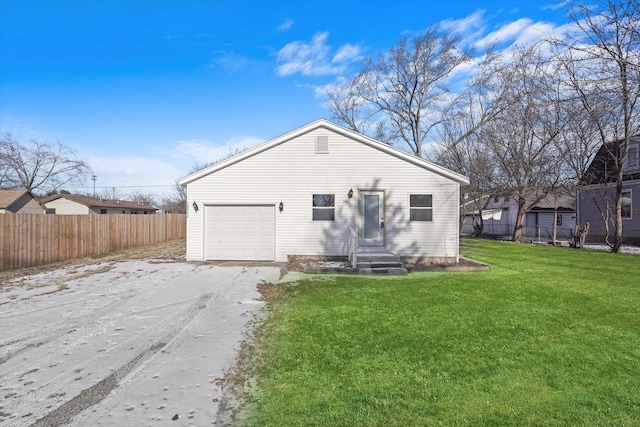 back of property with a garage and a yard