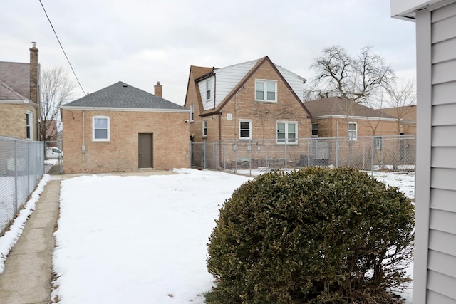 view of snow covered back of property