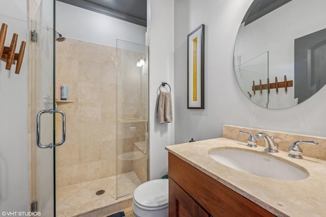 bathroom with a shower with door, vanity, and toilet