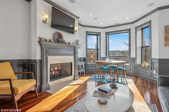 living room with crown molding, a fireplace, and dark hardwood / wood-style flooring