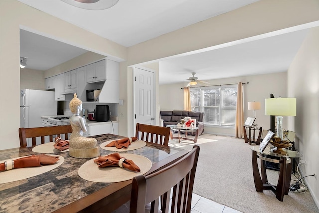 carpeted dining area with ceiling fan