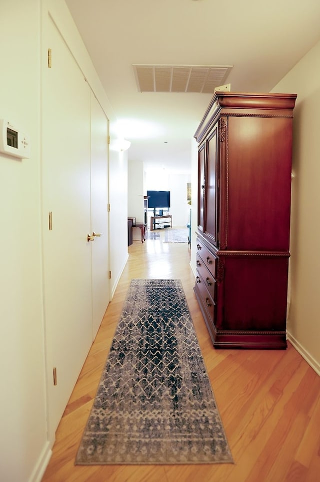 hallway featuring light wood-type flooring and visible vents