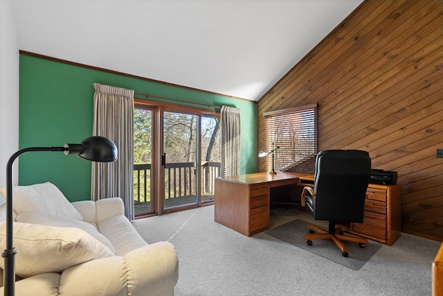 carpeted home office with lofted ceiling and wood walls