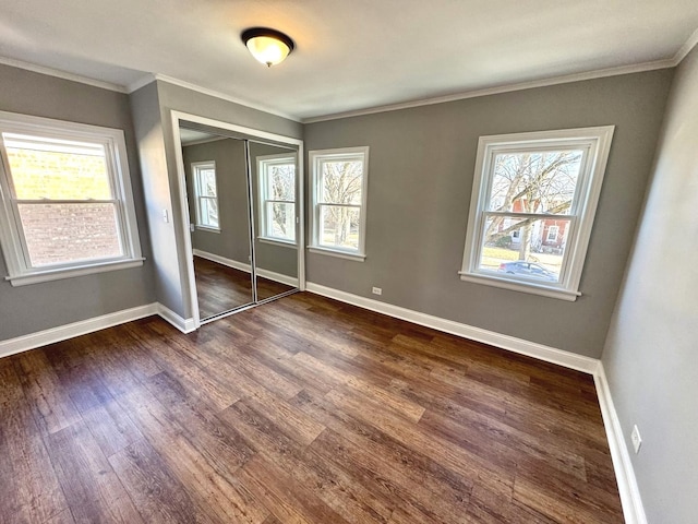 unfurnished bedroom with crown molding, dark wood-type flooring, and a closet