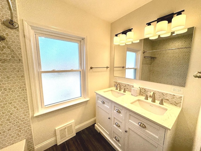 bathroom featuring hardwood / wood-style flooring, vanity, and walk in shower