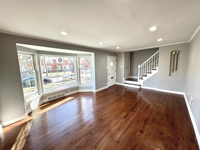 unfurnished living room featuring ornamental molding and dark hardwood / wood-style flooring