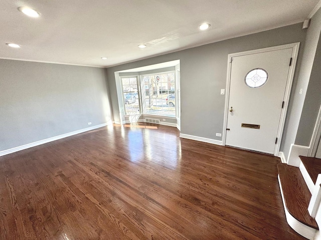 foyer featuring ornamental molding and dark hardwood / wood-style flooring